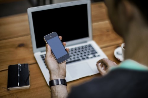 Man using cell phone and laptop